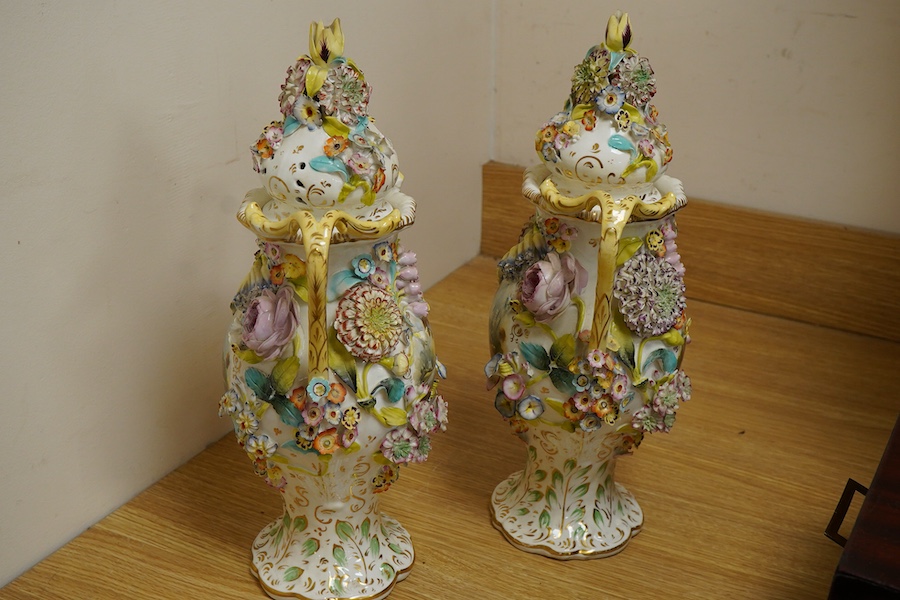 A pair of English porcelain floral encrusted vases and covers, c.1830, possibly Samuel Alcock, each painted with landscapes, 44cm high